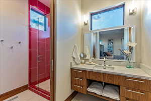 Bathroom with visible vents, baseboards, a shower stall, ensuite bath, and vanity