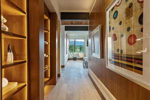 Hallway with wooden walls and light wood-style floors