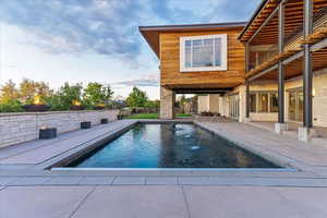 View of swimming pool with a fenced in pool and a patio
