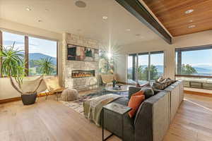 Interior space with a fireplace, light wood-style flooring, beamed ceiling, and a mountain view
