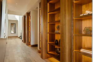 Corridor with light wood-style flooring and baseboards