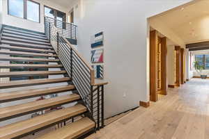 Stairway with a towering ceiling, hardwood / wood-style flooring, baseboards, and visible vents