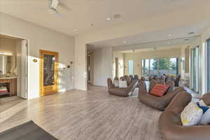 Living area with recessed lighting, ceiling fan, light wood finished floors, and baseboards