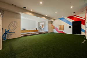 Rec room with carpet floors, recessed lighting, a putting area, and golf simulator