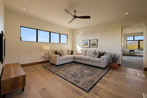 Living area with ceiling fan, recessed lighting, light wood-type flooring, and baseboards