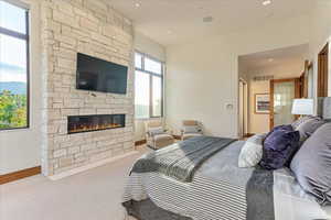 Carpeted bedroom with a fireplace, visible vents, and baseboards