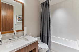 Full bathroom with toilet, shower / bath combo, and vanity