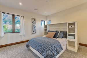 Carpeted bedroom featuring visible vents, baseboards, and recessed lighting