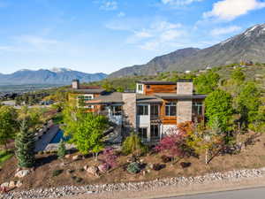 View of front of property with a chimney, a sunroom, and a mountain view
