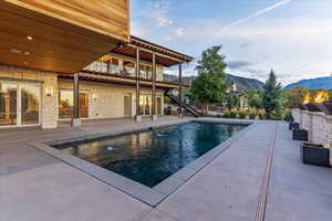 Pool with a patio area, stairway, and a mountain view
