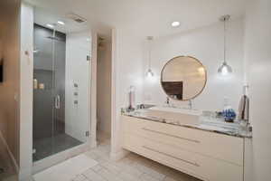 Full bathroom featuring tile patterned flooring, vanity, toilet, a shower stall, and visible vents