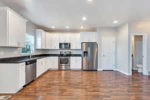 Kitchen featuring appliances with stainless steel finishes, a sink, visible vents, and dark wood finished floors
