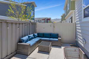 View of patio with outdoor lounge area, fence, a gate, and a mountain view