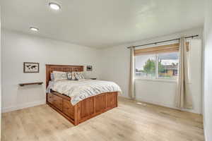 Bedroom featuring baseboards, light wood-style flooring, and visible vents