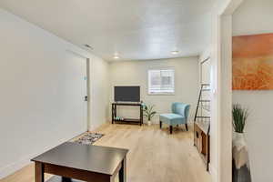 Living area with baseboards, visible vents, and light wood-type flooring