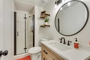 Full bath featuring tile patterned flooring, a stall shower, toilet, and visible vents