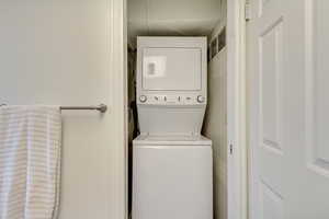 Laundry room featuring laundry area and stacked washer / drying machine