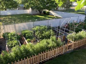 View of yard with a fenced backyard, a storage unit, an outdoor structure, and a garden