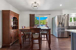 Dining room featuring recessed lighting, baseboards, dark wood-style floors, and a wealth of natural light