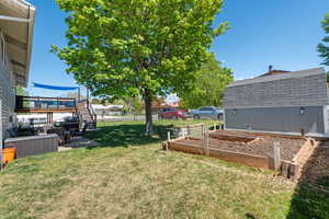View of yard with a wooden deck and a garden