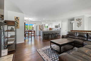 Living area featuring baseboards, recessed lighting, a textured ceiling, and dark wood-type flooring