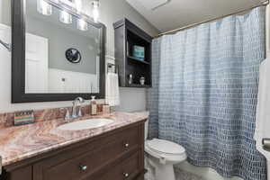 Full bath featuring vanity, a shower with shower curtain, and toilet