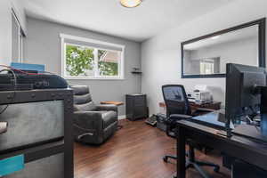Office area featuring a textured ceiling, baseboards, and wood finished floors