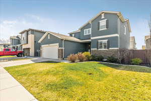 Craftsman house with concrete driveway, an attached garage, stone siding, and stucco siding