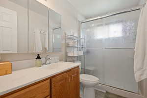 Bathroom featuring vanity, tile patterned floors, a shower stall, and toilet
