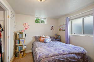 Bedroom with baseboards, carpet, a textured ceiling, and visible vents