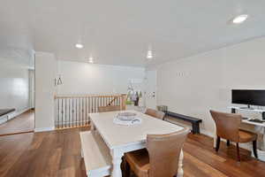 Dining area featuring a textured ceiling, baseboards, and dark wood-type flooring