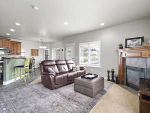 Living area with a tile fireplace, recessed lighting, and a notable chandelier