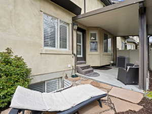 View of patio with fence, entry steps, and central AC unit