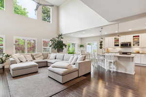 Living room featuring recessed lighting, a high ceiling, and dark wood-type flooring