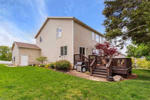 Back of property with a lawn and a deck