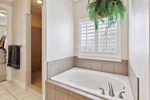 Bathroom with tile patterned floors, a shower stall, and a garden tub