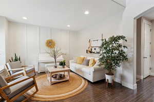 Living room featuring arched walkways, baseboards, recessed lighting, and wood finished floors
