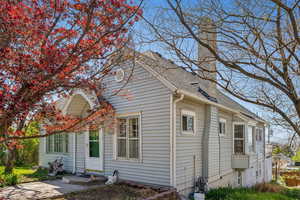 Back of property featuring roof with shingles and a chimney