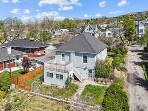 Rear view of property featuring a residential view, fence, and a shingled roof