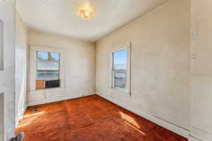 Carpeted empty room featuring baseboards, visible vents, cooling unit, and a wealth of natural light