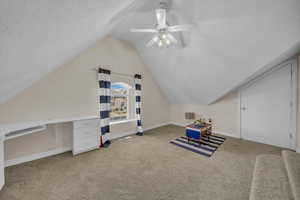 Additional living space with visible vents, baseboards, ceiling fan, carpet flooring, and vaulted ceiling
