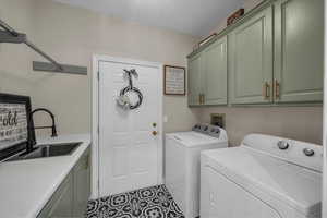 Laundry room with a sink, separate washer and dryer, and cabinet space