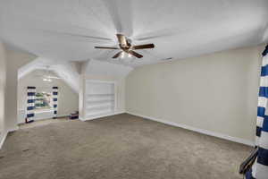 Interior space featuring a ceiling fan, a textured ceiling, visible vents, carpet floors, and baseboards
