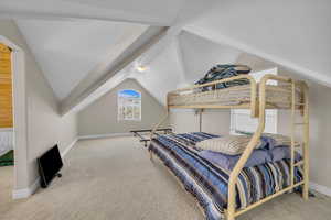 Bedroom featuring carpet floors, baseboards, and vaulted ceiling