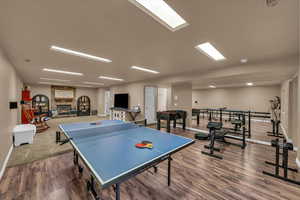 Game room featuring baseboards, a fireplace, and wood finished floors