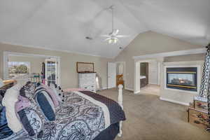 Bedroom with visible vents, light carpet, baseboards, high vaulted ceiling, and a ceiling fan