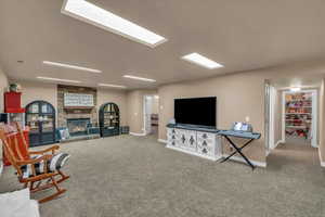 Carpeted living area featuring baseboards and a fireplace