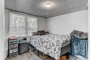 Carpeted bedroom featuring a textured ceiling