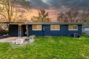 View of front of house with brick siding, central AC, and a front yard