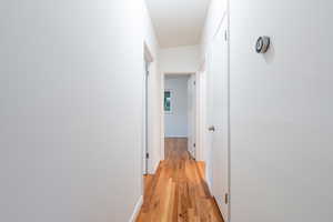 Hallway featuring baseboards and light wood-style flooring